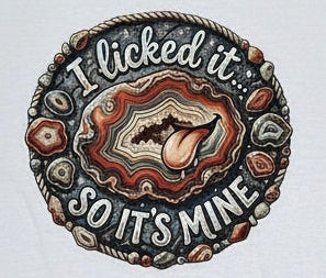 The center of the shirt features a circular graphic with a cartoon tongue sticking out of a agate, surrounded by the text 'I licked it SO IT'S MINE' in a retro font.