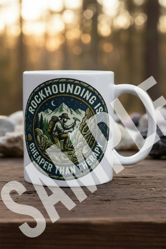 Circular sticker with a mountain scene and text 'Rockhounding is cheaper than therapy' on a white coffee cup.