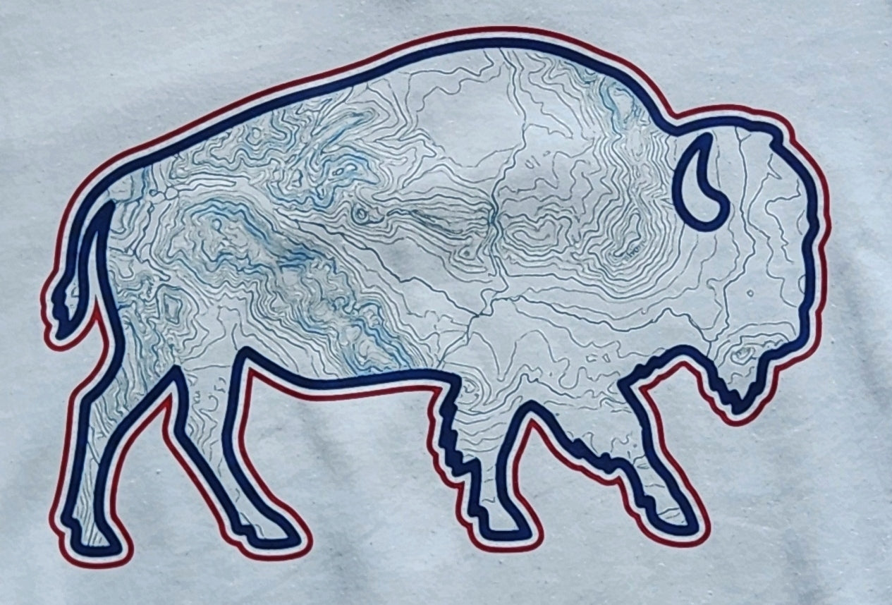 A close-up of a white fabric featuring a large bison silhouette graphic filled with blue topographic contour lines and outlined in dark blue with a thin red inner border.