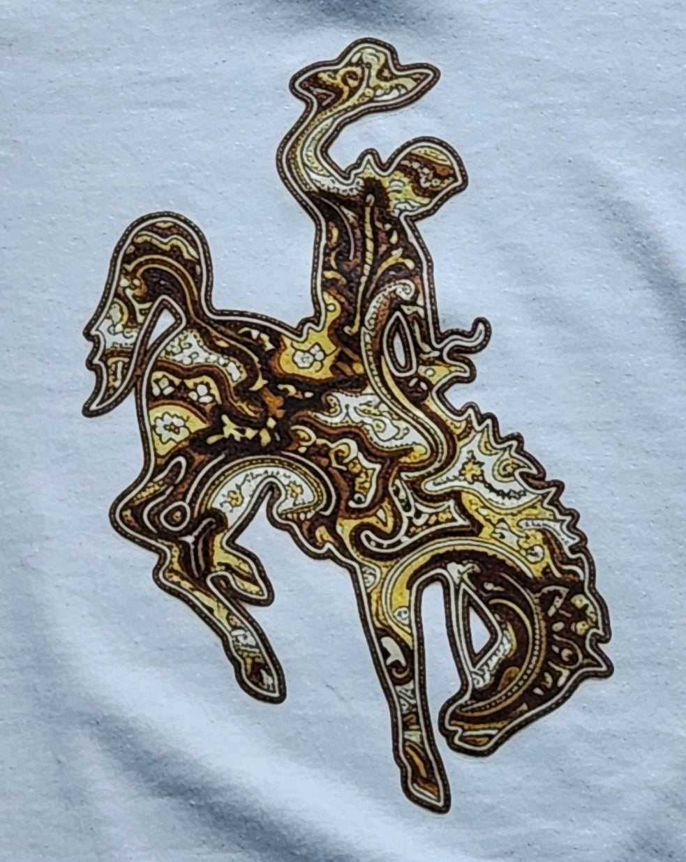 Wyoming bucking horse logo in a brown, yellow and white paisley pattern on white fabric. 