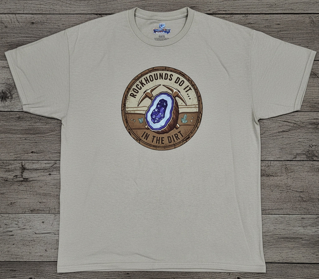 A light beige crewneck t-shirt with a circular graphic on the chest featuring a geode illustration and the text 'ROCKHOUNDS DO IT... IN THE DIRT.'