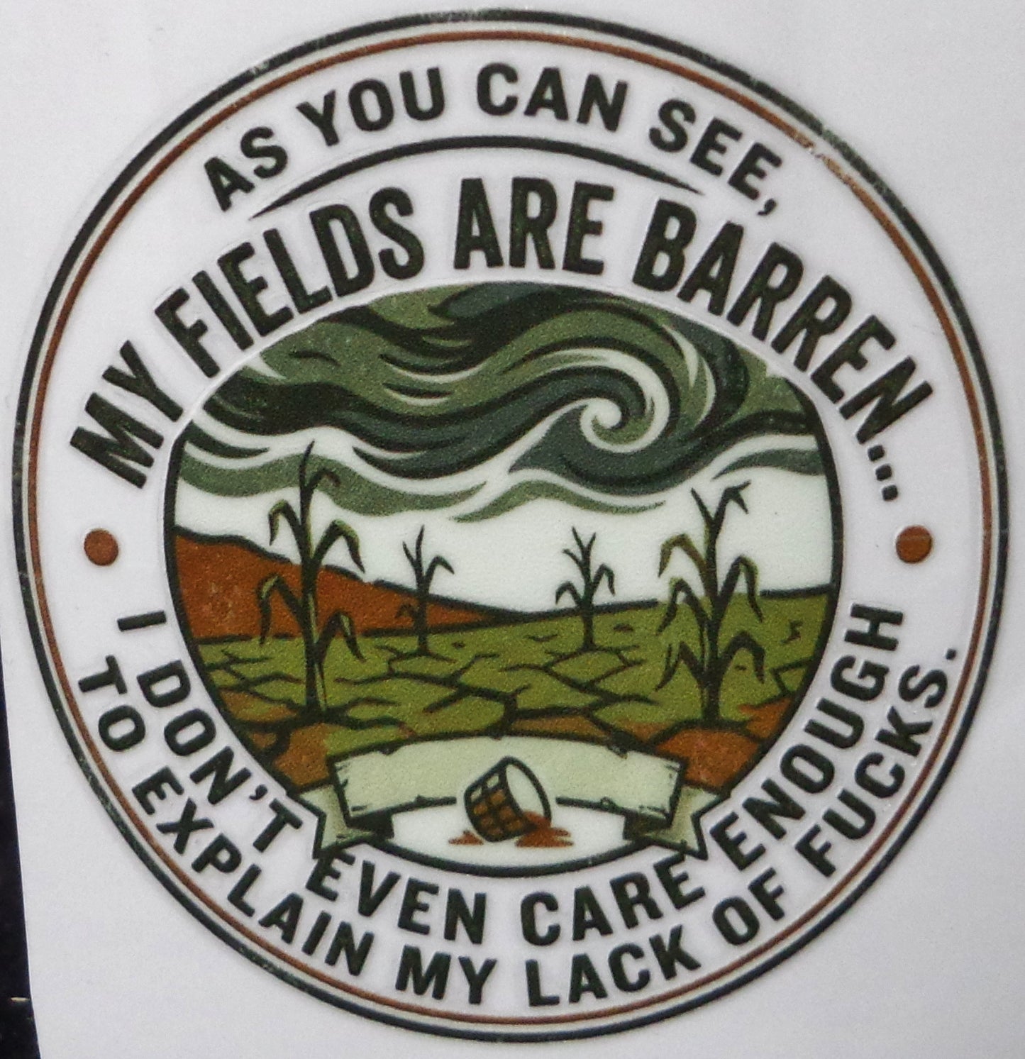 Circular sticker with text and graphic of a barren fields