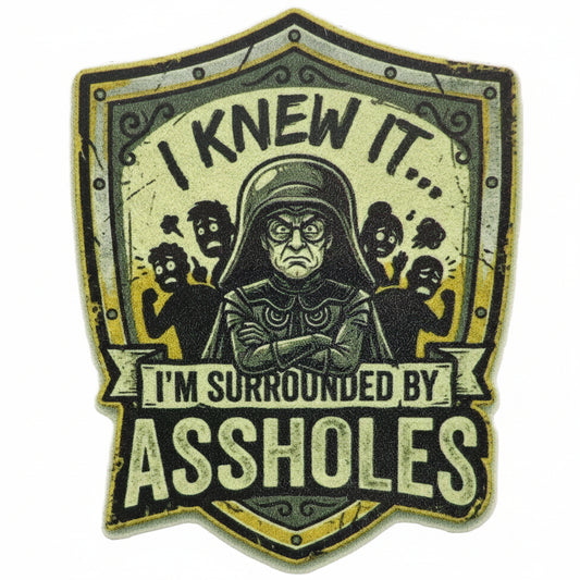 Sticker with text 'I knew it, I'm surrounded by assholes' on a shield design with a Lord Helmet and people in the background. Spaceballs