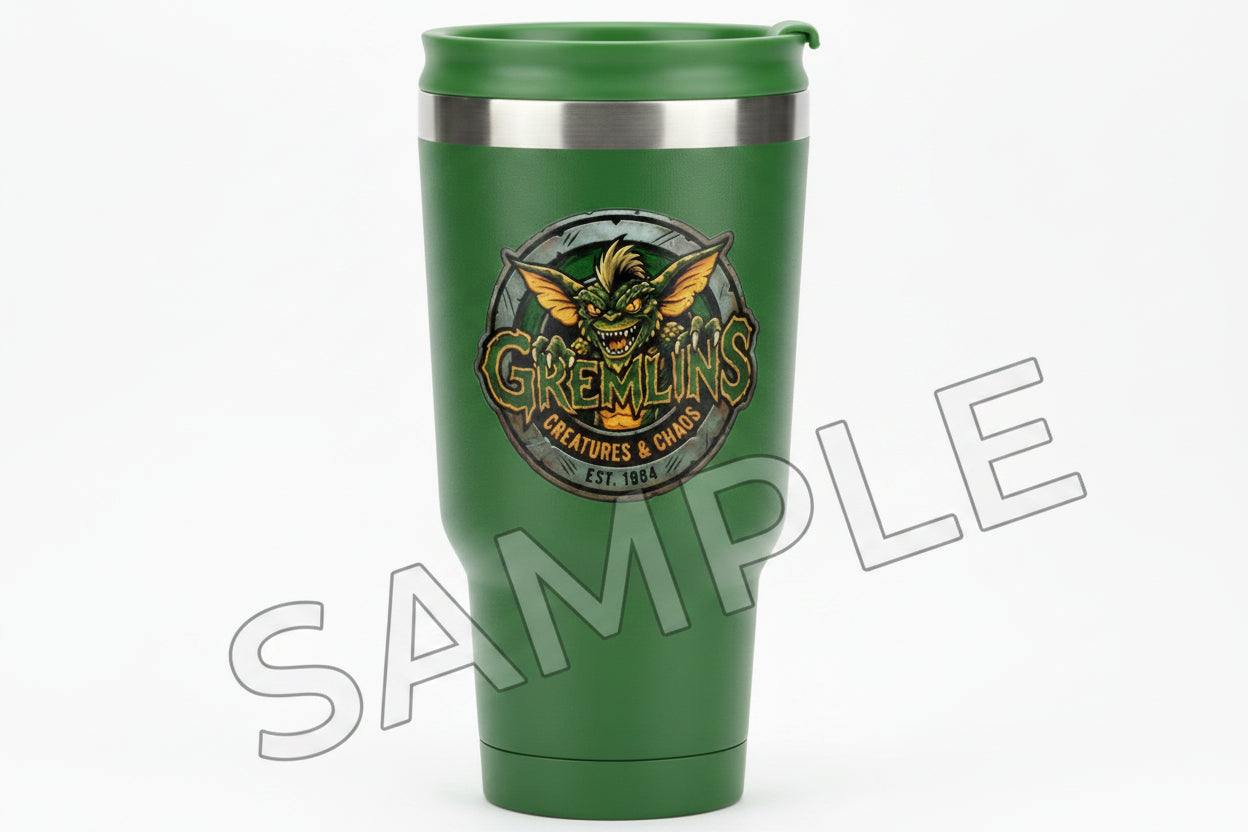 A circular novelty sticker featuring a grinning green gremlin, with the words 'GREMLINS' in large stylized letters across the front. Smaller text reads 'CREATURES & CHAOS' and 'EST.