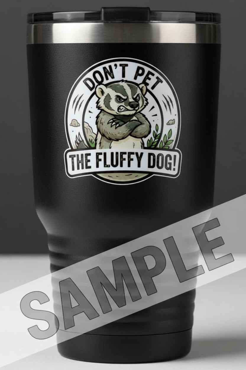 A black insulated travel tumbler with a stainless steel rim, featuring a circular graphic of a badger with the text 'DON'T PET THE FLUFFY DOG!'. 