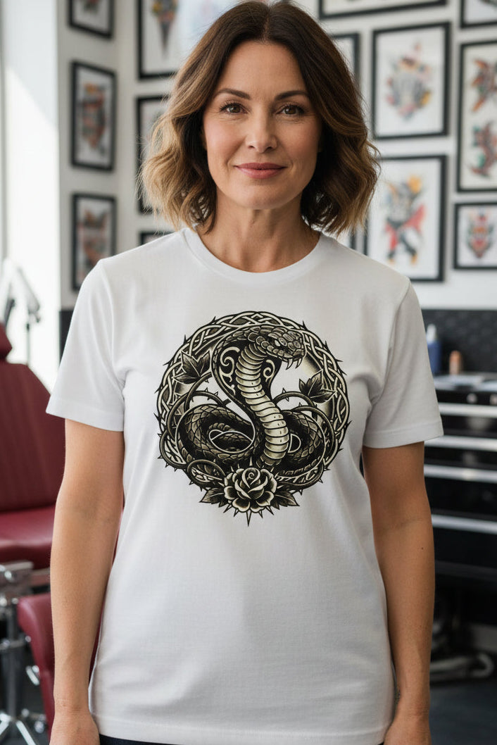 Woman wearing a white t-shirt with a snake design in a tattoo parlor.