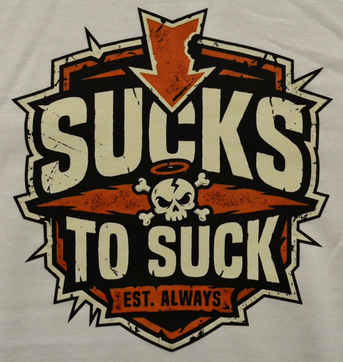 T-shirt with a graphic design featuring text "Sucks to Suck" and a skull on a white shirt
